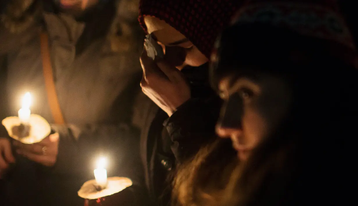 Seorang wanita menyeka airmatanya saat aksi dukungan pada komunitas muslim di Toronto, Senin (30/1). Dukungan itu setelah aksi penembakan di sebuah masjid di Kota Quebec, Kanada yang menewaskan 6 orang. (Chris Young/The Canadian Press via AP)
