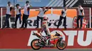 Marc Marquez merayakan kemenangannya di GP Argentina, Sirkuit Termas de Rio Hondo dengan berdiri di atas motornya menyambut rekan setimnya. (AFP/Juan Mabromata)