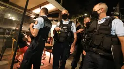 Polisi Prancis berpatroli untuk mengontrol kewajiban penggunaan masker di jalan-jalan Argeles-sur-Mer, Prancis selatan, Rabu (13/8/2020). Pemakaian masker di beberapa area ramai di sekitar Paris merupakan kewajiban sebagai upaya untuk membendung peningkatan tajam infeksi covid-19. (RAYMOND ROIG/AFP)