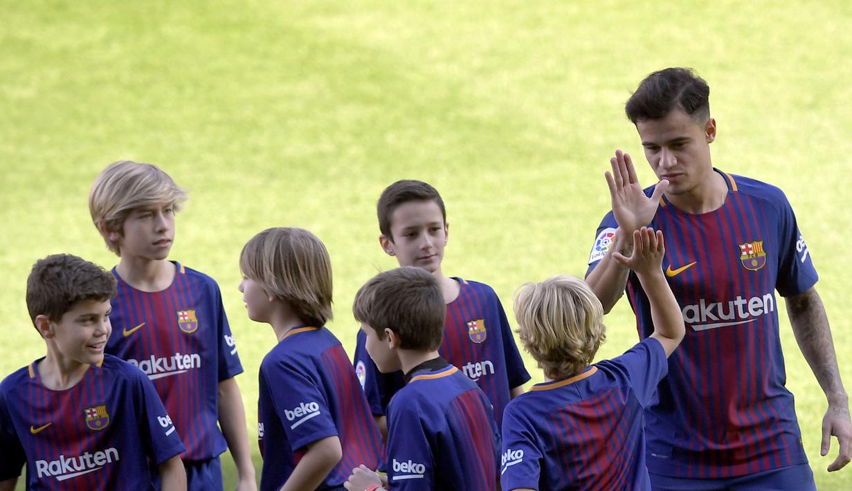 Philippe Coutinho siap bertanding dengan anak-anak pada sesi perkenalan di Camp Nou stadium, Barcelona, Spain, (8/01/2018). Coutinho bergabung dengan Barcelona dari Liverpool dengan nilai transfer sebesar 160 juta euro. (AFP/Lluis Gene)