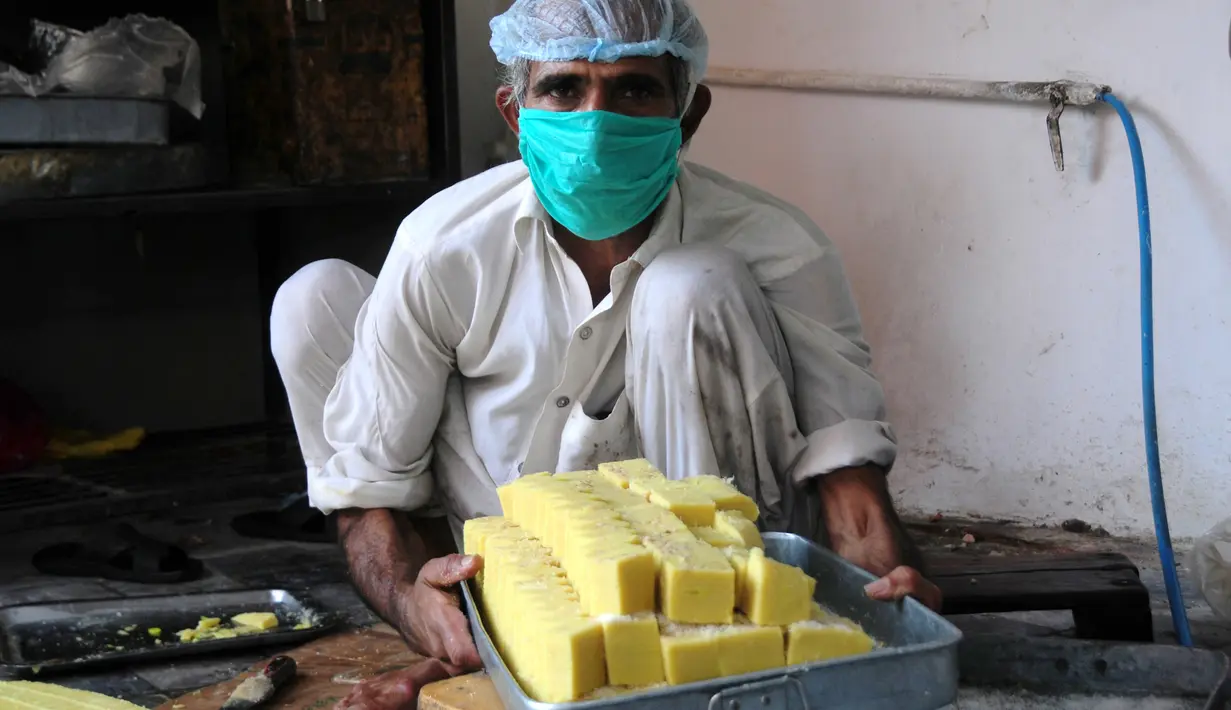 Seorang pria membuat penganan manis tradisional di hari raya Idul Fitri di Peshawar, Pakistan barat laut, pada 25 Mei 2020. Warga Pakistan memiliki tradisi memakan penganan manis saat merayakan Idul Fitri, yang menandai akhir bulan puasa Ramadan. (Xinhua/Saeed Ahmad)