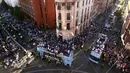 Pemain Manchester City melambaikan tangan dari atas bus beratap terbuka saat parade merayakan keberhasilan menjadi juara Liga Primer Inggris di Manchester, Senin (14/5). Sekitar 100 ribu fans ManCity membirukan Kota Manchester. (Danny Lawson/PA via AP)