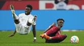 Penyerang Bayern Munchen, Alphonso Davies dan bek  Bayer Leverkusen Jeremie Frimpong terjatuh saat bertabrakan pada laga pekan ke-25 Liga Jerman 2022/2023 di Stadion BayArena, Senin (20/3/2023) dini hari WIB. (AP Photo/Martin Meissner)