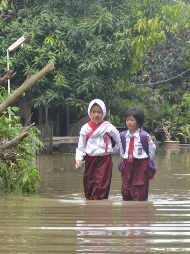 Dua siswa SD menerabas banjir di Sidareja, Cilacap, Jawa Tengah (20/9/2016). (Foto: Liputan6.com/Muhamad Ridlo)