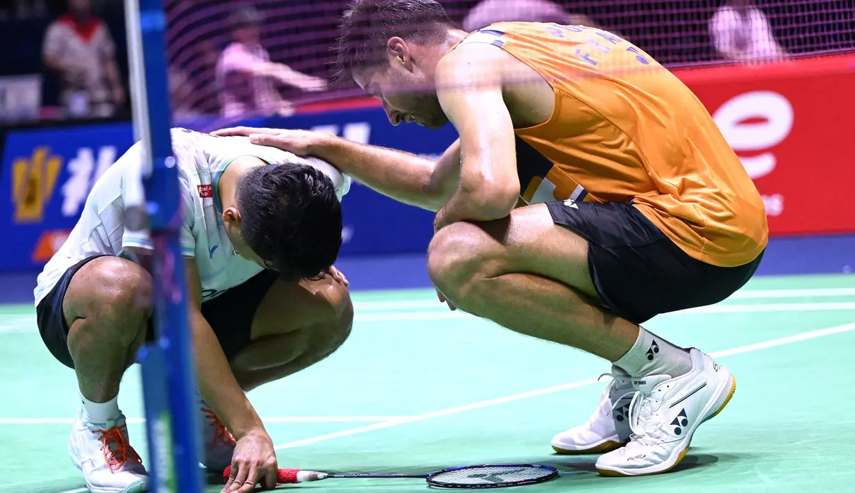 Pebulu tangkis Indonesia, Anthony Sinisuka Ginting (kiri) tertunduk usai dikalahkan Toma Junior Popov (Prancis) pada pertandingan tunggal putra di Kejuaraan Dunia BWF di Adidas Arena, Paris, pada 26 Agustus 2025. (Bertrand GUAY/AFP)
