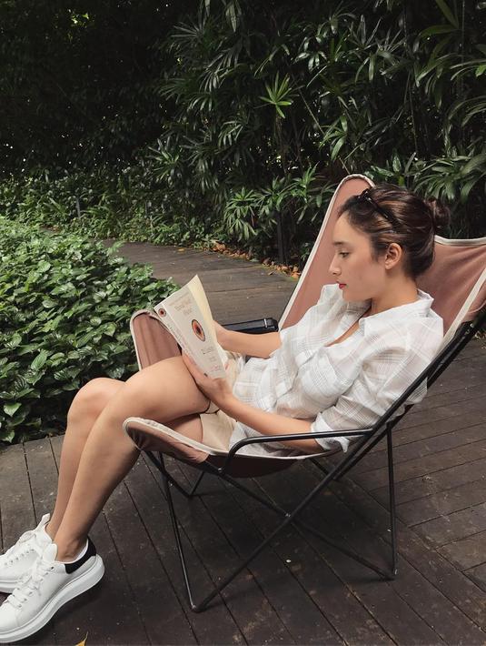 Saat tidak menjalani kegiatan sebagai aktris, Tatjana Saphira memilih untuk menghabiskan waktu membaca buku. Dengan penampilan santainya ini, Tatjana terlihat fokus menikmati lembar demi lembar di buku yang dibacanya.(Liputan6.com/IG/@tatjanasaphira)