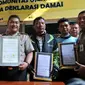 Petugas kepolisian bersama pengemudi ojek online dan ojek pangkalan memperlihatkan deklarasi damai komunitas ojek pangkalan dengan komunitas ojek online di Polsek Kebun Jeruk, Jakarta (22/9/2015). (Liputan6.com/Gempur M Surya)