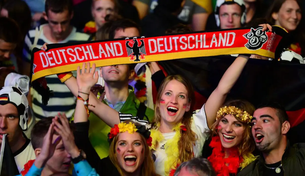 Senyum gembira fans atas kemenangan Jerman pada pertandingan final Piala Dunia 2014, Brasil, Senin (14/7/14). (AFP/JOHN MACDOUGALL)