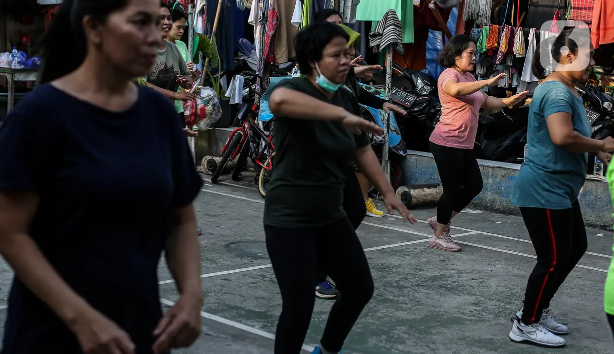 Sejumlah perempuan mengikuti senam bersama di sebuah lapangan kawasan Jakarta, Rabu (25/8/2021). Untuk menjaga tubuh tetap sehat dan imun yang terjaga di kala pandemi, warga melakukan senam rutin yang dipimpin instruktur seminggu sekali. (Liputan6.com/Johan Tallo)