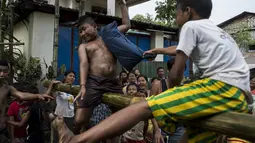 Seorang anak terpukul bantal saat mengikuti Perang Bantal di Yangon, Rabu (4/1). Acara tersebut digelar dalam rangka HUT Kemerdekaan Myanmar ke-69. (AFP PHOTO / YE AUNG THU)