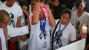Ekspresi sedih orang tua Kian Loyd, Saldy delos Santos (tengah) saat berada di dekat peti mati putranya di Caloocan, Filipina (26/8). Mereka yang ikut mengiringi pemakaman menggunakan kaos putih bertuliskan 'Justice for Kian.' (AP Photo/Bullit Marquez)