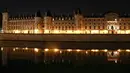 Pandangan umum dari Conciergerie tercermin di sungai Seine pada malam hari selama penerapan lockdown atau penguncian wilayah di Paris, 23 April 2020. Pandemi corona COVID-19 membuat Prancis menerapkan lockdown. (Ludovic MARIN / AFP)