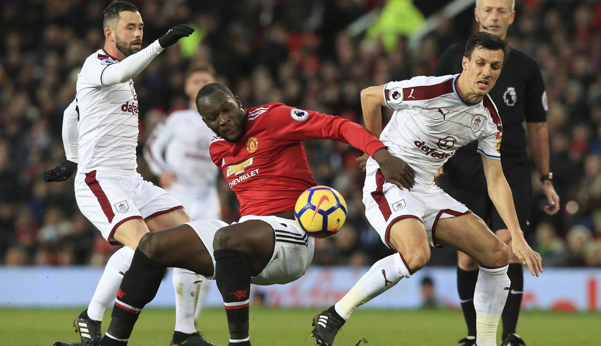 Pemain Manchester United, Romelu Lukaku (tengah) berebut bola dengan dua pemain Burnley  pada lanjutan Premier League di Old Trafford,  Manchester (26/12/2017).  MU bermain imbang 2-2. (AFP/Lindsey Parnaby)