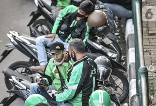 Pengemudi ojek online (ojol) memenuhi bahu jalan saat menunggu penumpang di kawasan Cililitan, Jakarta, Rabu (16/9/2020). Pemprov DKI Jakarta telah melarang ojol dan ojek pangkalan berkumpul lebih dari lima orang serta menjaga jarak sepeda motor minimal dua meter. (merdeka.com/Iqbal S. Nugroho)