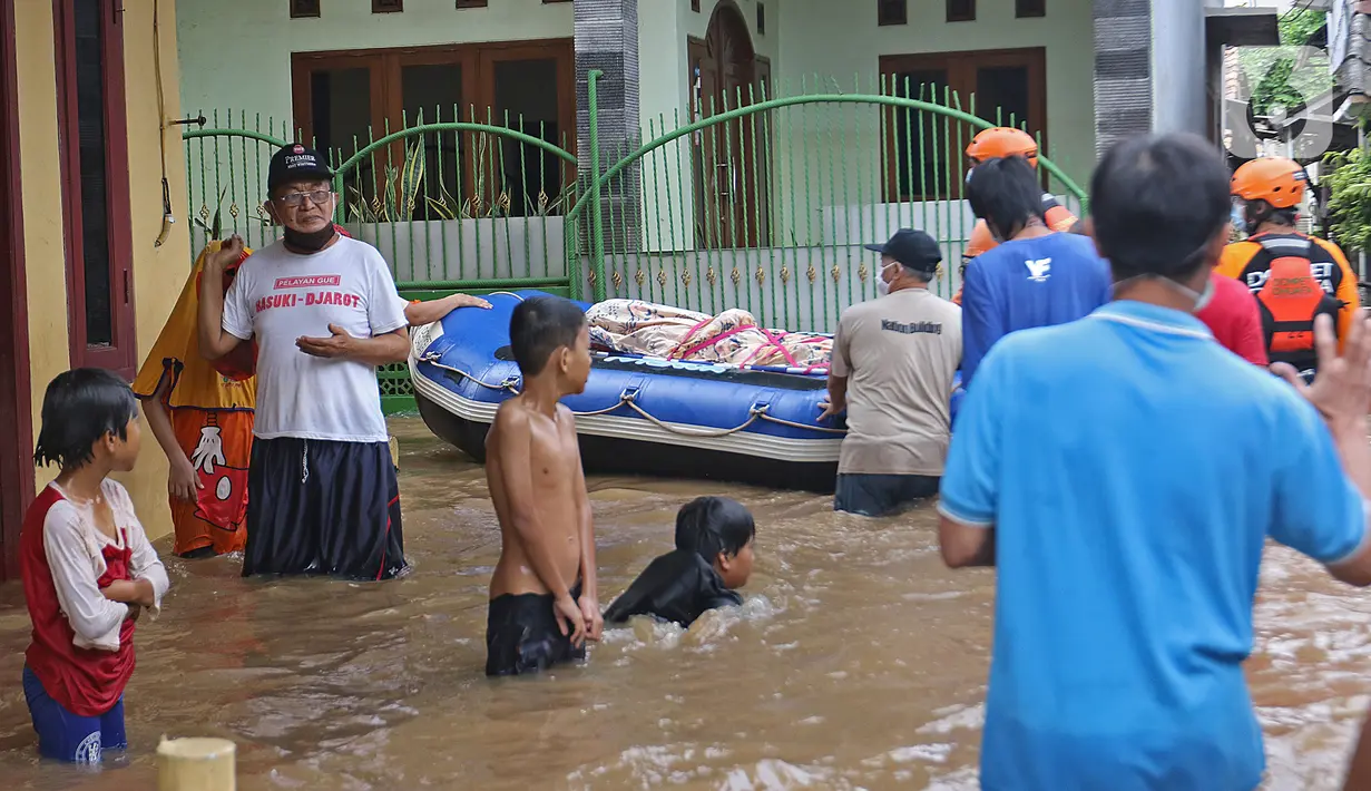 Relawan dan keluarga membawa jenazah warga lansia dengan perahu karet saat banjir di kawasan Cipinang Melayu, Jakarta Timur, Jumat (19/2/2021). Seorang nenek (80) meninggal di kediamannya, di lokasi banjir, di RW 04, kawasan tersebut karena sakit dan sudah lanjut usia. (Liputan6.com/Herman Zakharia)