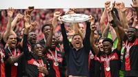 Xabi Alonso mengangkat trofi gelar juara Bundesliga bersama Bayer Leverkusen. (INA FASSBENDER / AFP)