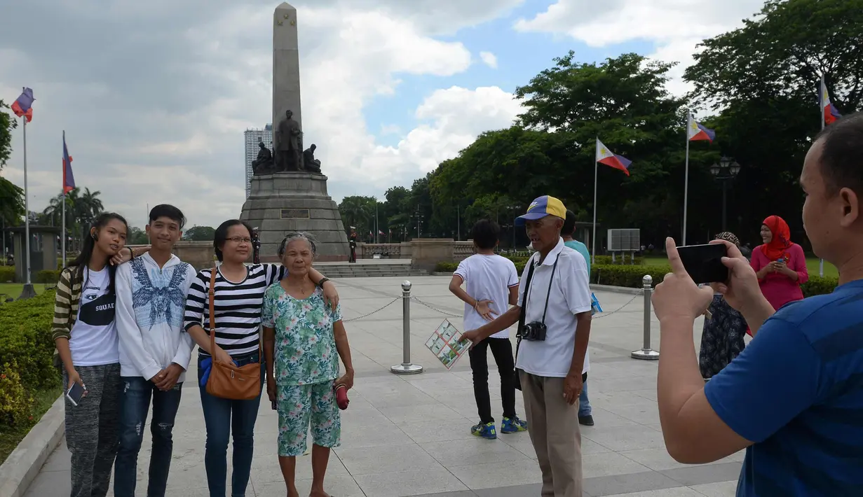 Fotografer taman, Joel Estrella menawarkan jasa foto kepada wisatawan di sebuah taman di Manila, Filipina (22/4). Estrella telah bekerja sebagai fotografer taman sejak tahun 1970. (AFP Photo/Ted Aljibe)