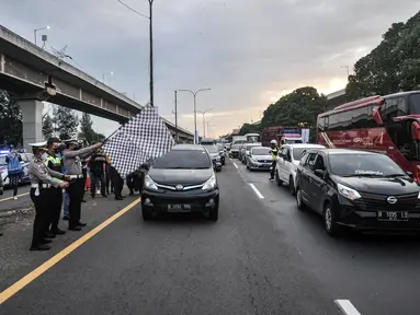 Polisi secara simbolis membuka sistem one way di ruas Tol Jakarta-Cikampek KM 47, Karawang, Jawa Barat, Kamis (28/4/2022). Kebijakan one way di ruas Tol Jakarta-Cikampek KM 47 hingga Tol Kalikangkung KM 414 diterapkan mulai hari ini sebagai upaya mengurai kemacetan kendaraan para pemudik. (Liputan6.com/Iqbal S. Nugroho)