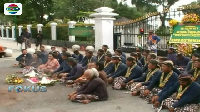 Mereka duduk bersila di depan gerbang sambil memanjatkan doa.