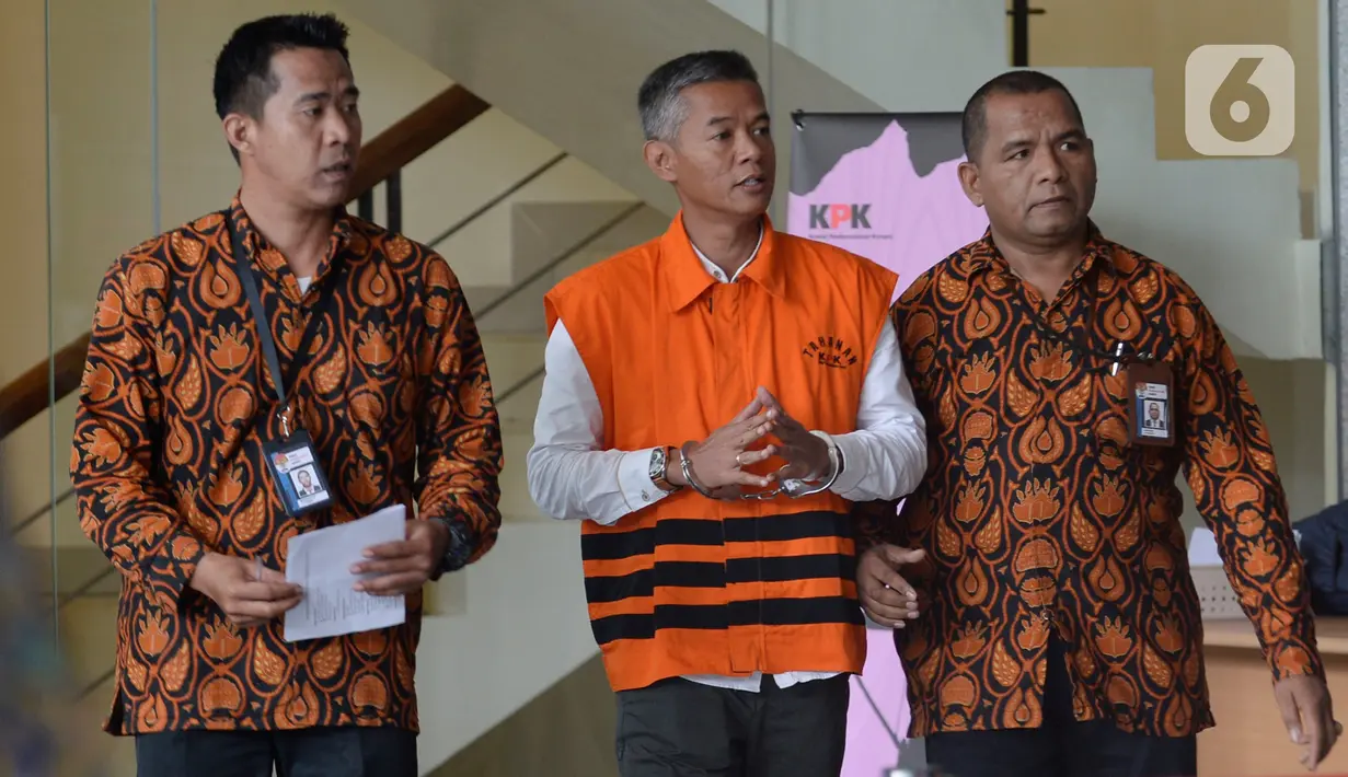 Komisioner KPU Wahyu Setiawan (rompi tahanan) dikawal petugas seusai menjalani pemeriksaan di gedung KPK, Jakarta, Rabu (15/1/2020). Wahyu Setiawan diperiksa perdana setelah ditetapkan sebagai tersangka terkait dugaan penerimaan suap penetapan anggota DPR terplih 2019-2020. (merdeka.com/Dwi Narwoko)