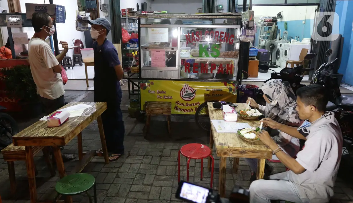 Pelanggan menikmati nasi goreng buatan mantan pegawai fungsional Biro Hukum KPK, Juliandi Tigor Simanjuntak di Jalan Raya Hankam, Bekasi, Rabu (13/10/2021). Tigor berjualan nasi goreng setelah dipecat KPK bersama 57 rekannya yang tidak lolos tes wawasan kebangsaan. (Liputan6.com/Helmi Fithriansyah)