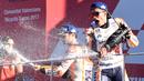 Pembalap Spanyol Repsol Honda, Marc Marquez (kanan) dan pembalap Dani Pedrosa (tengah) merayakan kemenangannya di atas podium pada balapan MotoGP Grand Prix Valencia di Sirkuit Ricardo Tormo, Valencia (12/11). (AFP PHOTO / Jose Jordan)