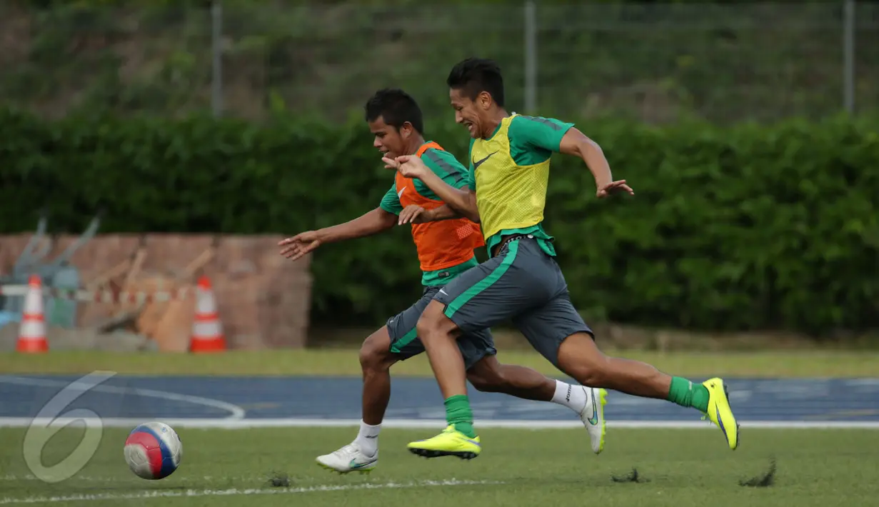 Dua penggawa timnas Indonesia U-23, Manahati Lestusen (kiri) dan Yandi Sofyan berebut bola saat latihan di Temasek Polytechnic, Singapura, Kamis (4/6/2015). Timnas Indonesia akan melawan Kamboja pada 6 Juni mendatang. (Liputan6.com/Helmi Fithriansyah)