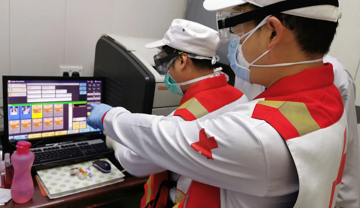 Anggota tim pakar medis China, Chen Huai (depan) dan Ai Hexu memeriksa citra tomografi terkomputasi dada di Baghdad, Irak, Senin (30/3/2020). Sejak 7 Maret lalu, tujuh pakar medis China bekerja sama dengan tenaga ahli lokal di Irak untuk memerangi epidemi virus corona COVID-19. (Xinhua)