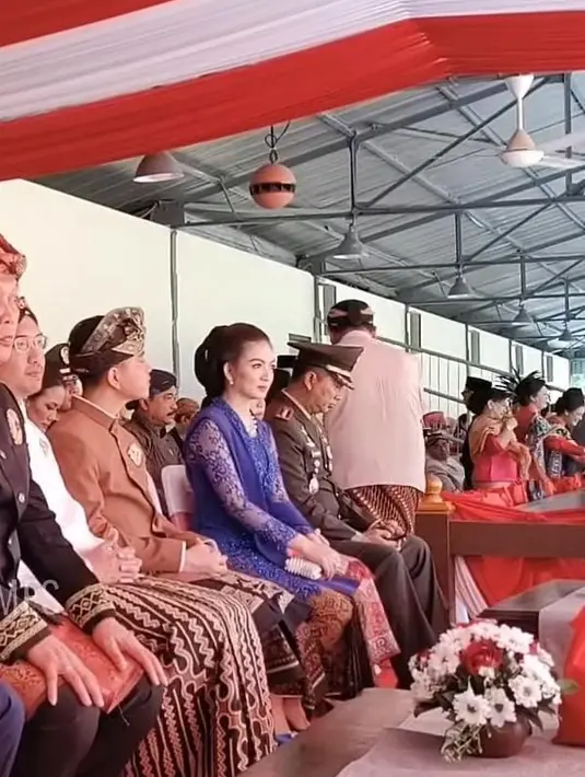 Lalu anak pertamanya, Gibran merayakan HUT RI ke 78 di Solo. Saat upacara terlihat ia mengenakan pakaian adat Bali terlihat dari hiasan kepala dan kain bawahannya. Sedangkan sang istri, tampil dengan kebaya navy brokat lengkap dengan selendang dan kainnya. [Tangkap Layar Solo Times]