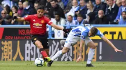 Penyerang Manchester United, Alexis Sanchez, berusaha melewati pemain Huddersfield Town, Erik Durm, pada laga Premier League di Stadion John Smith, Minggu (5/5). Kedua tim bermain imbang 1-1. (AP/Anthony Devlin)