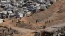 Aktivitas pekerja Mesir yang menggunakan alat berat untuk mencari jenazah para sandera di Kota Hamad, Khan Younis, di Jalur Gaza selatan, Selasa 28 Oktober 2025. Upaya ini dilakukan di tengah gencatan senjata yang disepakati antara Israel dan Hamas. (AP Photo/Abdel Kareem Hana)