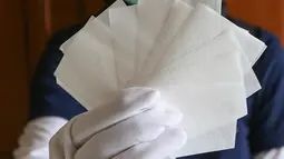 Pekerja menunjukkan sabun cuci tangan berukuran lembaran kertas di Gemilang Craft Pamulang, Tangerang Selatan, Kamis (23/4/2020). Sabun cuci tangan yang dikemas dalam pouch gemilang sebagai alternatif pengganti hand sanitizer selama pandemi Covid-19. (Liputan6.com/Fery Pradolo)