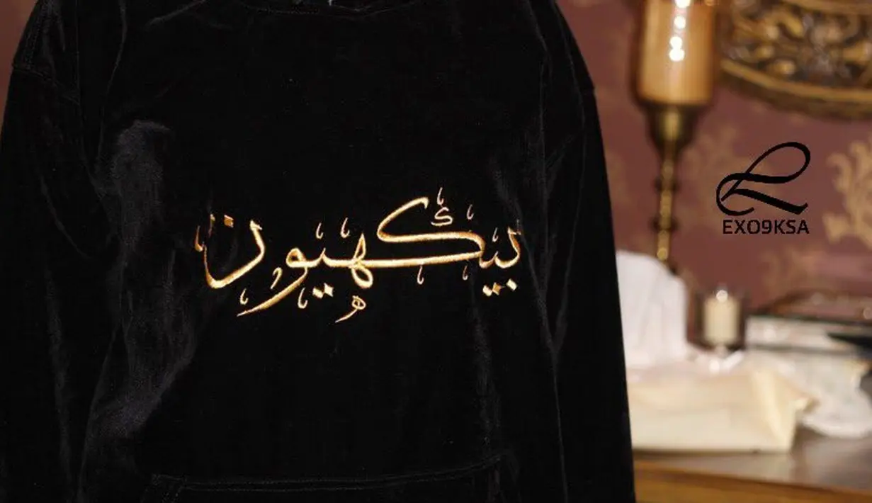 Pada bagian belakang, terdapat nomor jersey para personel EXO dalam angka Arab. Tulisan nama dan nomor jersey itu sendiri berwarna emas. (Foto: koreaboo.com)