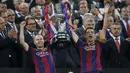Gelandang Barcelona, Xavi Hernandes (kiri) dan Andres Iniesta mengangkat trofi Copa del Rey usai memenangkan Final Piala Raja di Nou Camp, Spanyol (31/5/2015). Barcelona berhasil menaklukkan Bilbao dengan skor akhir 3-1. (Reuters/Albert Gea)