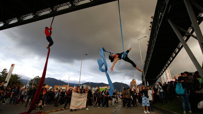 Sejumlah mahasiswa bergelantungan menggunakan tali pada sebuah jembatan saat menuntut peningkatan anggaran pendidikan di Bogota, Kolombia, Rabu (31/10). (AP Photo/Fernando Vergara)