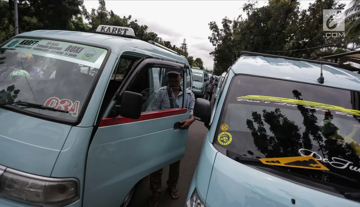 Para pengemudi angkutan memarkirkan mobilnya saat menggelar unjuk rasa di depan Balai Kota, Jakarta, Senin (22/1). Mereka meminta untuk membuka kembali Jalan Jatibaru Raya dan putaran di depan Blok A Tanah Abang. (Liputan6.com/Faizal Fanani)