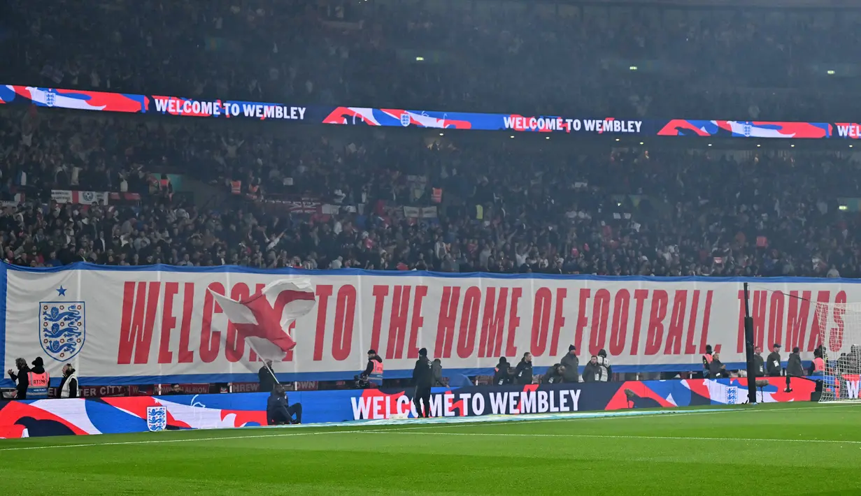 Pendukung Timnas Inggris membentangkan banner untuk menyambut debut Thomas Tuchel sebagai pelatih saat laga Kualifikasi Piala Dunia 2026 melawan Albania di Wembley Stadium, London, Jumat (21/03/2025) waktu setempat. (AFP/Glyn Kirk)