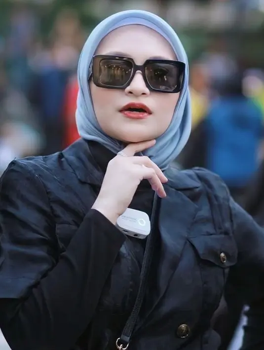 Nathalie Holscher rajin mengunggah penampilan terbaru di akun Instagram terverifikasinya. Jumat (29/7/2022), ibu satu anak ini mengunggah foto saat mengenakan luaran hitam yang dipadukan dengan kacamata warna senada dan hijab biru muda tanpa motif. Posenya banjir pujian. “Semenjak pisah aura ka natalie makin ksini makin cantikk masyaallah kak,” tulis @shell*** di kolom komentar. “Aura kecantikannya semakin berpendar bunda,” @mary*** menyahut. (Foto: Dok. Instagram @nathalieholscher)