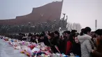 Penduduk Pyongyang meletakkan bunga di depan patung pemimpin Korea Utara Kim Il Sung dan Kim Jong Il selama Hari Peringatan Nasional di Bukit Mansu, Pyongyang (17/12).  Korea Utara tengah memperingati 7 tahun wafatnya  Kim Jong Il. (AFP Photo/Kim Won Jin)