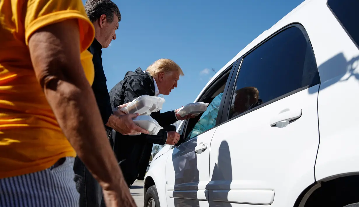 Presiden AS, Donald Trump membagikan makanan kepada korban badai Florence di Temple Baptist Church di New Bern, N.C. (19/9). Badai Florence menewaskan sedikitnya 32 orang. (AP Photo/Evan Vucci)