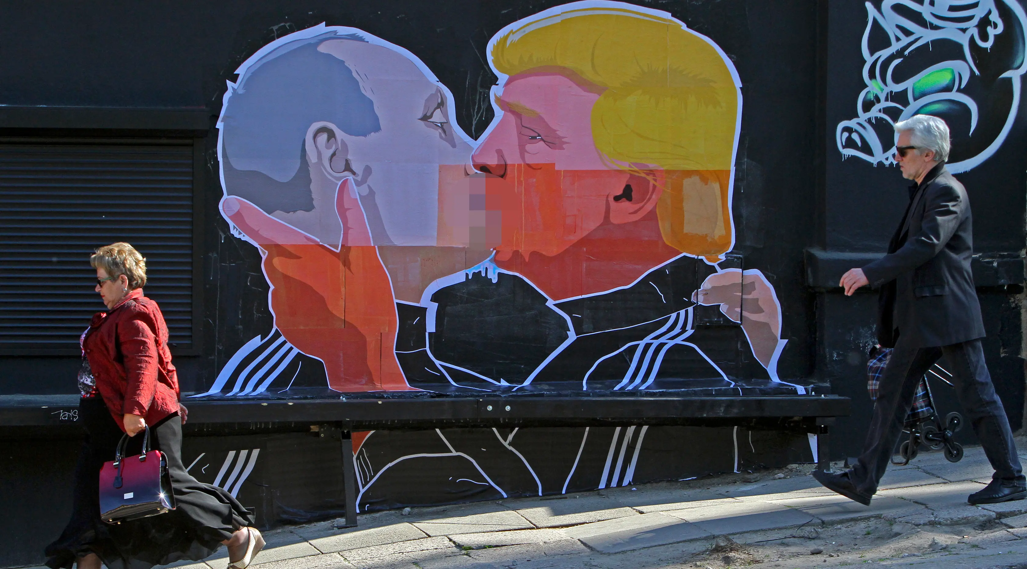 Warga melewati mural bergambar calon Presiden AS, Donald Trump dan Presiden Rusia, Vladimir Putin sedang berciuman di Vilnius, (13/5). Mural ini dibuat sebagai sindiran terhadap Donald Trump dan Vladimir Putin. (AFP PHOTO/Petras Malukas)