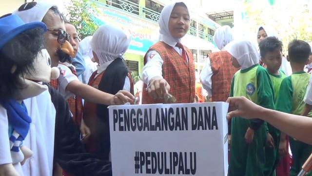 Para siswa SD menyumbangkan uang untuk para korban gempa Palu, salah satunya bahkan rela memberikan sebuah celengan berisi uang saku.