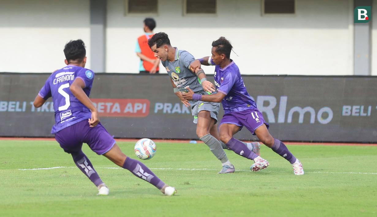 <p>Pemain Persebaya Surabaya, Bruno Moreira (tengah) berusaha melewati pemain Persita Tangerang, Muhammad Toha pada laga pekan ke-25 BRI Liga 1 2023/2024 di Stadion Indomilk Arena, Tangerang, Jumat (23/2/2024). (Bola.com/M Iqbal Ichsan)</p>