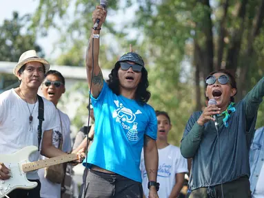 Duet Menteri Susi Pudjiastuti dengan Personel Slank, Kaka dan Ridho dalam pawai Bebas Sampah Plastik di Taman Aspirasi Monas, Jakarta, Minggu (21/7/2019). Pawai mengajak masyarakat untuk menolak penggunaan plastik sekali pakai karena sudah mengancam lingkungan. (Liputan6.com/Immanuel Antonius)