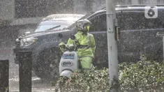 Pengendara motor mengenakan jas pelindung saat hujan mengguyur kawasan Monas, Jakarta Pusat, Kamis (5/1/2023). Badan Meteorologi, Klimatologi, dan Geofisika (BMKG) menyatakan beberapa wilayah Indonesia seperti Sumatera bagian selatan, Jawa, dan Bali mulai memasuki periode puncak musim hujan. (merdeka.com/Iqbal S Nugroho)
