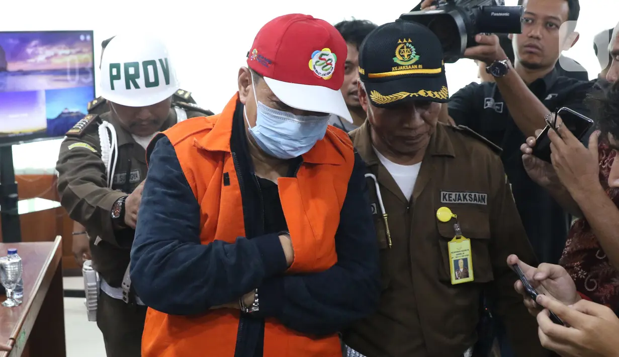 Buronan koruptor Atto Sakmiwata Sampetoding (tengah) digiring petugas di Gedung Kejaksaan Agung, Jakarta, Kamis (21/11/2019). Tim Kejagung bersama Ditjen Imigrasi dan KBRI Kuala Lumpur memulangkan buronan koruptor Rp 24 miliar yang telah divonis 5 tahun penjara. (Liputan6.com/Helmi Fithriansyah)