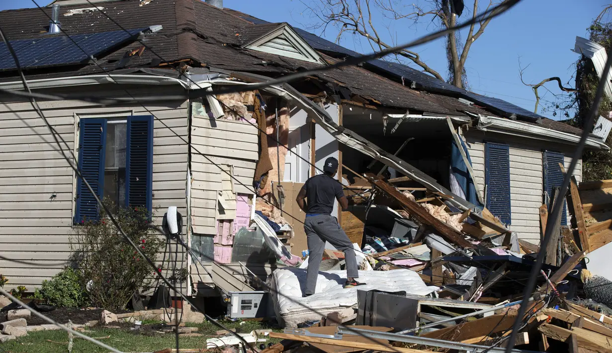 Kennell Harris merekam kerusakan rumah keluarga di Tita Street di Algiers, sebuah lingkungan di New Orleans, Kamis (15/12/2022). Gubernur Louisiana John Bel Edwards mengatakan, sebanyak 21 tornado telah menghantam wilayah pada Selasa dan Rabu, meninggalkan jejak kerusakan yang cukup parah. (David Grunfeld/The Times-Picayune/The New Orleans Advocate via AP)