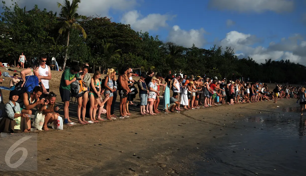 Ratusan wisatawan menyaksikan pelepasan tukik di Pantai Kuta Bali, 31 Agustus 2015. Pelepasan tukik merupakan upaya pelestarian habitat penyu yang mulai punah di kawasan Pantai Kuta, Bali. (Liputan6.com/Helmi Fithriansyah)