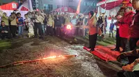 Menteri Sosial, Tri Rismaharini menyalakan api unggun pada peringatan HUT ke- 20 Tagana di halaman kantor Bupati Aceh Utara. (Liputan6.com/Dicky Agung Prihanto)