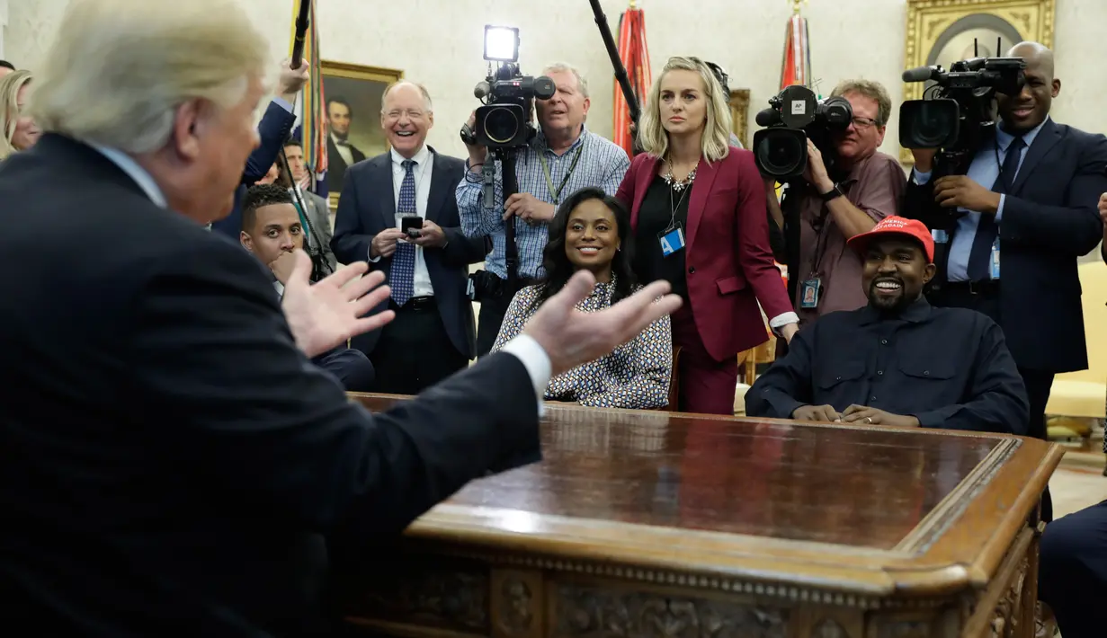 Presiden AS, Donald Trump bertemu dengan rapper Kanye West di Oval Office, Gedung Putih, Kamis (11/10). Pertemuan Kanye West dan Trump menjadi pertemuan kedua pada tahun ini setelah sebelumnya ia diundang Trump pada Mei lalu. (AP/Evan Vucci)